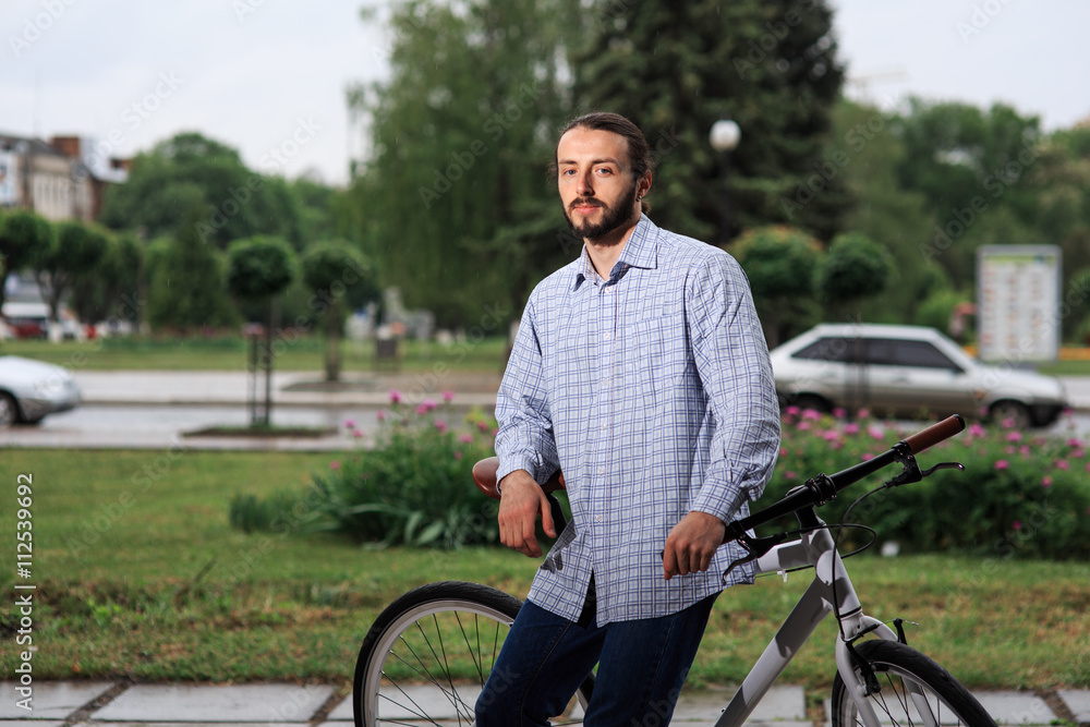 young hipster man with fixed gear bike on city street