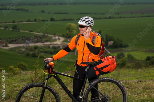 Young Male Cyclist Talking On Cell Phone