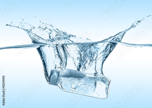 The moisturizing shampoo, cosmetic liquid, tonic falls into the blue water with big water splash on the gradient blue water background

