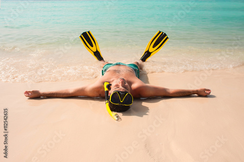 Man, relaxing in yellow black flippers fins and mask.