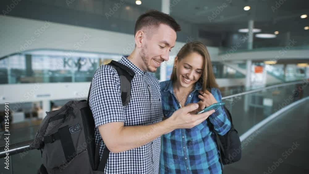 The guy shows something on a smartphone to his girlfriend. The guy shows something on a smartphone to his girlfriend.