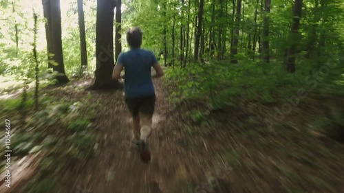 Wallpaper Mural Adult man running jogging outdoors in a forest nature on a forest trail and enjoying it and looking happy Torontodigital.ca
