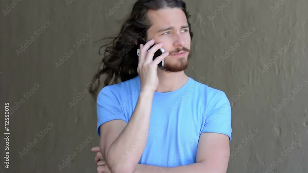 Young using the phone. Middle twenties. Long hair and blue eyes Young using the phone. Middle twenties. Long hair and blue eyes