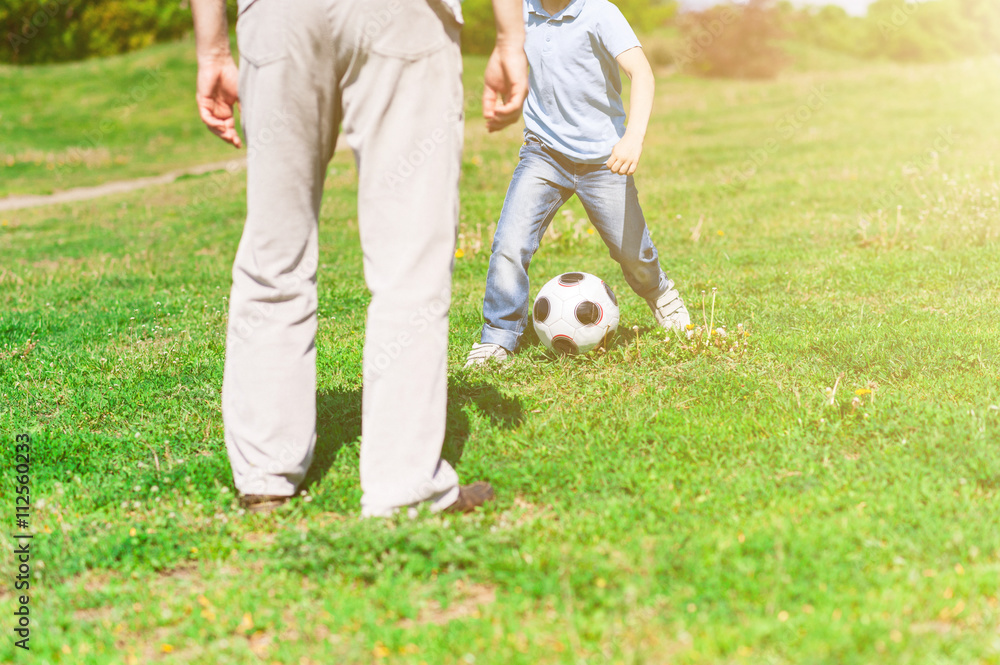Cute grandchild and grandparent playing football together