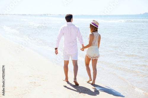 Couple walking at the beach on a sunny day