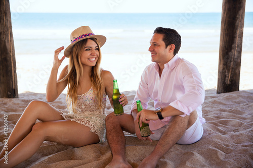 Couple enjoying the beach and some beer
