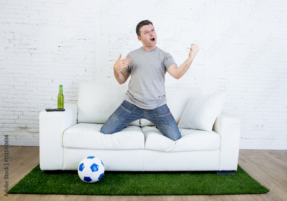 football fan watching tv match on sofa with grass pitch carpet celebrating  goal foto de Stock | Adobe Stock