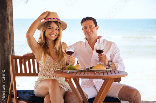 Pretty young couple eating at the beach