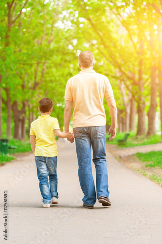 Cheerful boy and grandparent walking in the nature