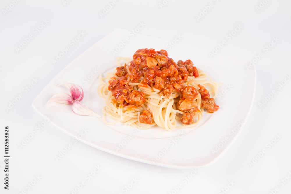 Spaghetti bolognese on a plate decorated with garlic cloves Spaghetti bolognese on a plate decorated with garlic cloves