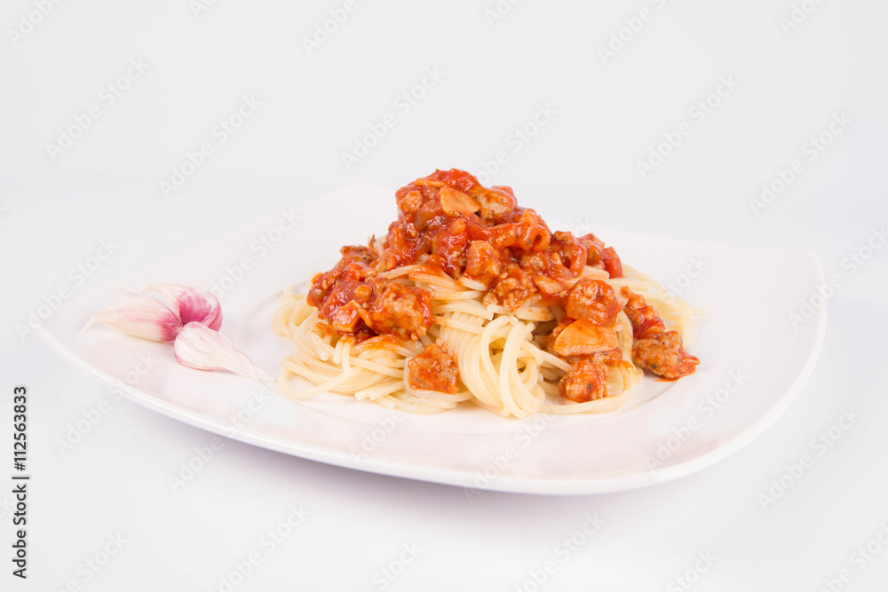 Spaghetti bolognese on a plate decorated with garlic cloves Spaghetti bolognese on a plate decorated with garlic cloves