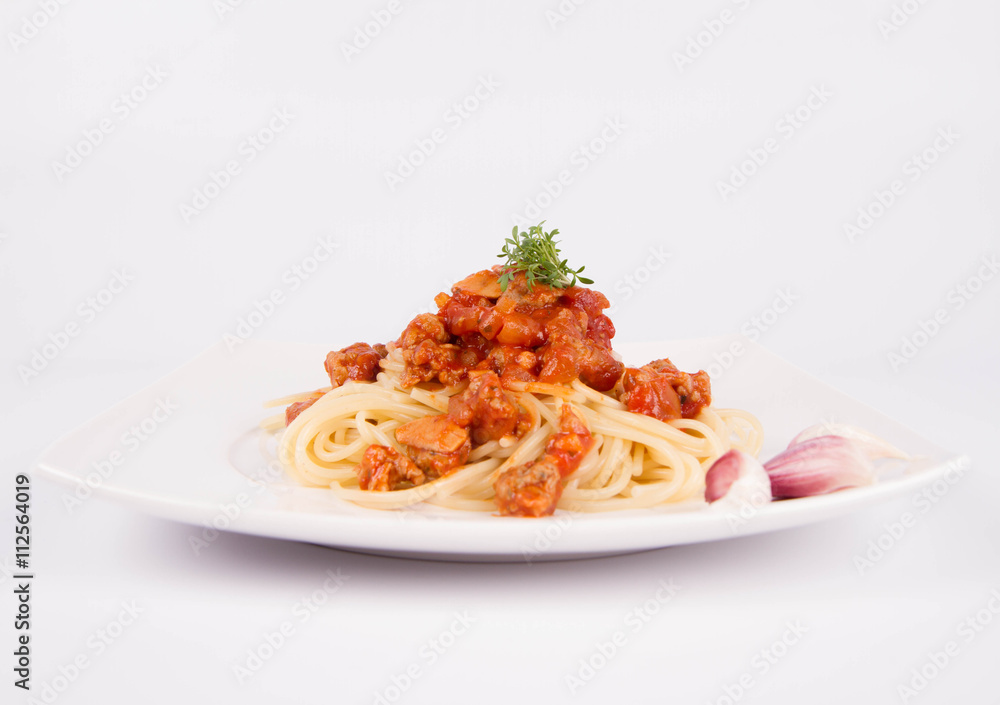 Spaghetti bolognese on a plate decorated with garlic cloves and cress Spaghetti bolognese on a plate decorated with garlic cloves and cress