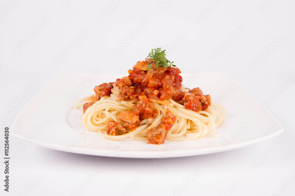 Spaghetti bolognese on a plate decorated with garlic cloves