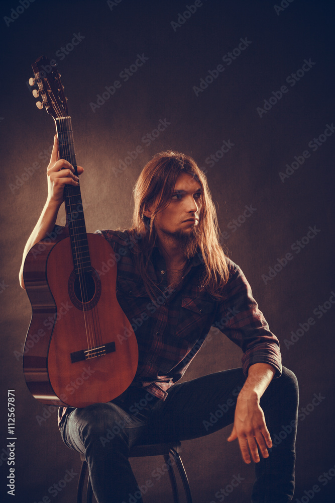 Young man holding guitar. Young man holding guitar.