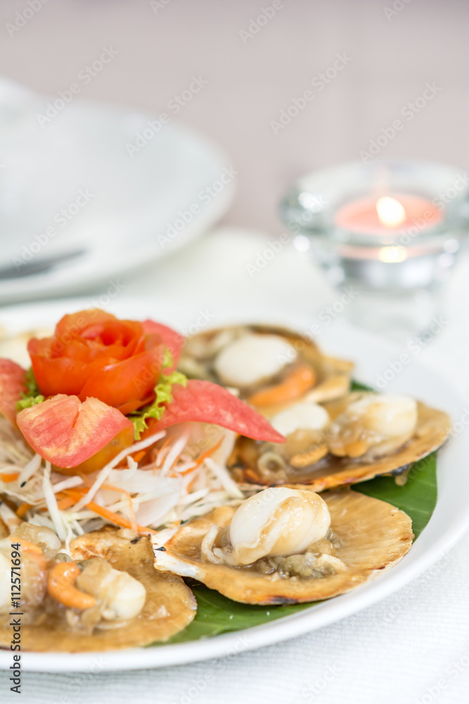 Baked scallops with butter and soy sauce in natural scallop shell delicious Thai seafood. Baked scallops with butter and soy sauce in natural scallop shell delicious Thai seafood.