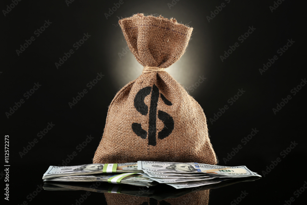 Money bag with dollars on black background Stock Photo | Adobe Stock