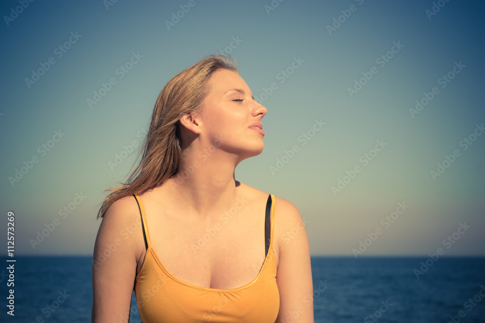 Lovely blonde girl relaxing outdoor by seaside