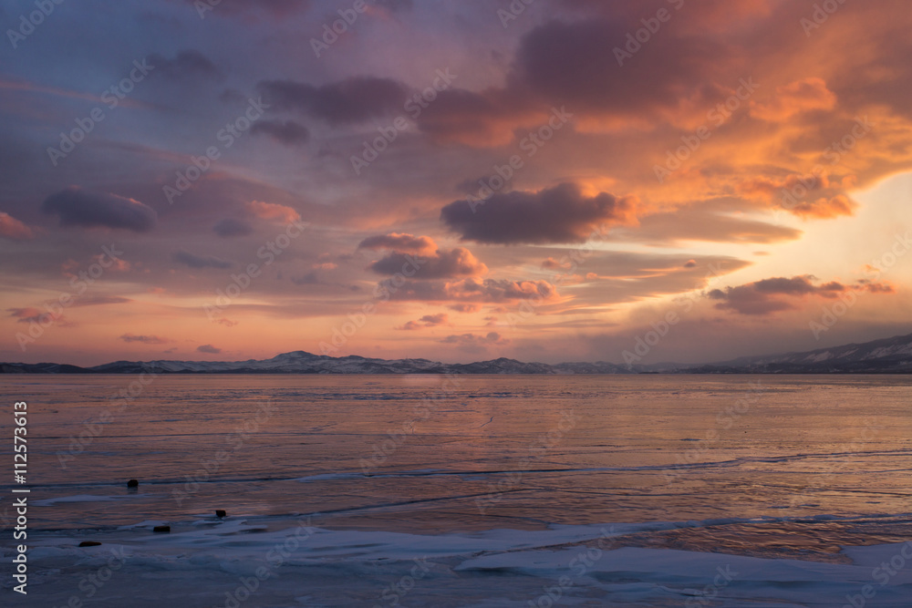 Ice and beautiful sunset at ice of lake Baikal on sunset
