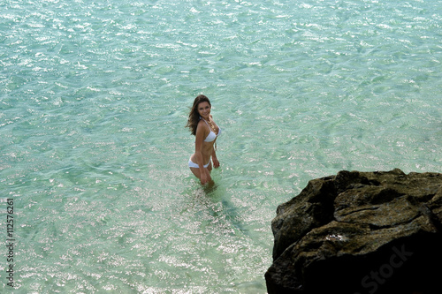 Pretty beautiful woman in white swimwear bikini posing in blue sea water © Dmitry Tsvetkov