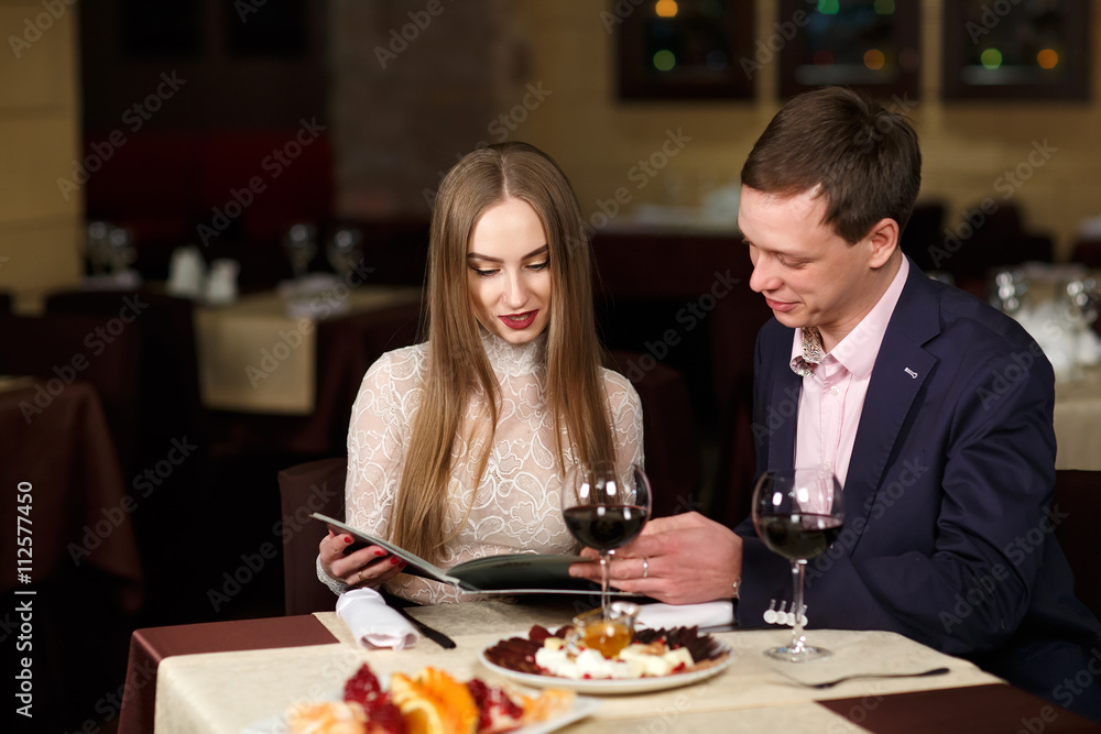 Cheerful couple with menu in a restaurant.