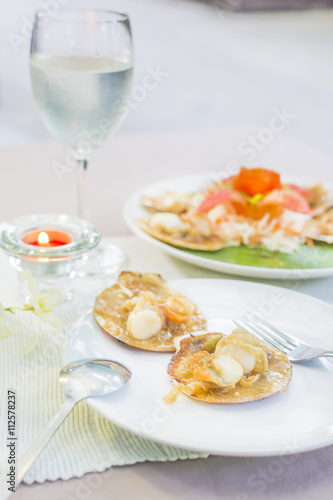 Baked scallops with butter and soy sauce in natural scallop shell delicious Thai seafood.