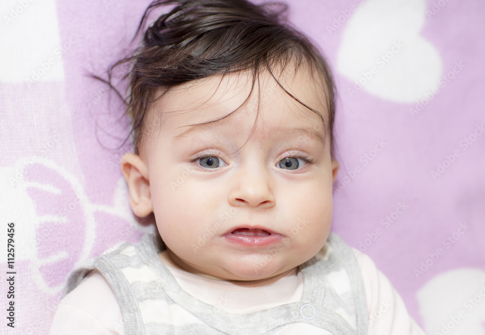 Portrait of little girl close up. Six-month old baby making funny faces. Portrait of little girl close up. Six-month old baby making funny faces.