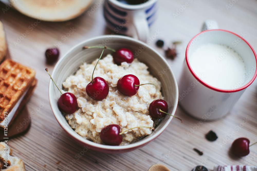 rich breakfast of porridge with cherries and pastry rich breakfast of porridge with cherries and pastry