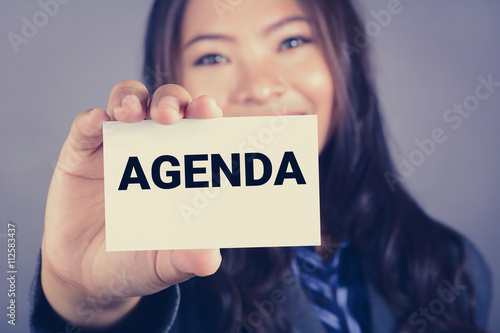 AGENDA word on the card shown by a businesswoman