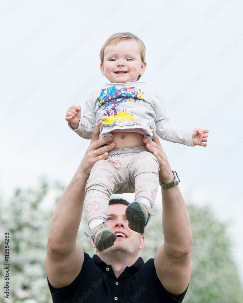 Fototapeta premium The father throws the little daughter up.