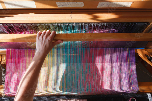 Bild auf Leinwand Hands of the woman weaving on a loom
