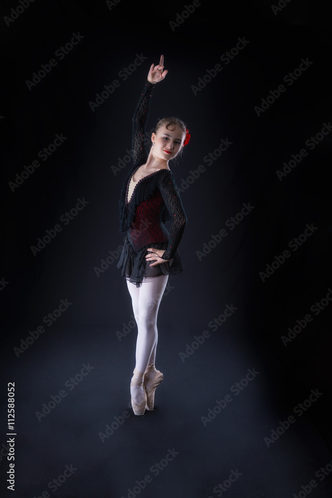 Ballerina in  black is dancing on a black background
