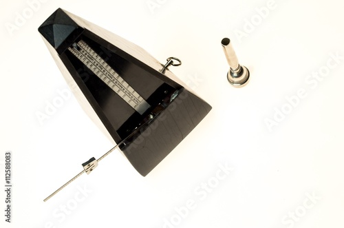 Metronome and mouthpiece of a trumpet isolated on a blank white