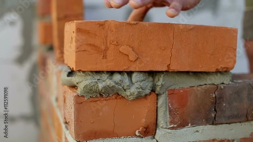 Work lays bricks on a construction site photo