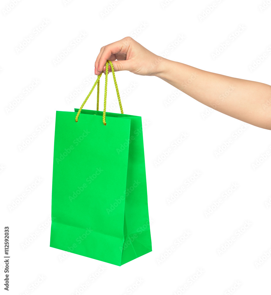 the hand holds a bright green bag for shopping isolated on white