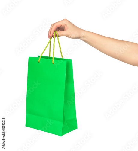 the hand holds a bright green bag for shopping isolated on white