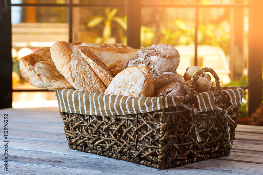 Wicker basket with bread. Bread and buns inside basket. Fresh bakery  products on table. Tastes best when warm. Stock Photo | Adobe Stock