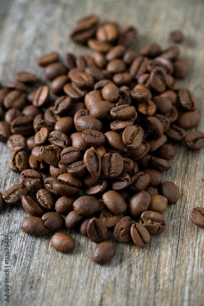 Naklejka premium coffee beans on wooden surface