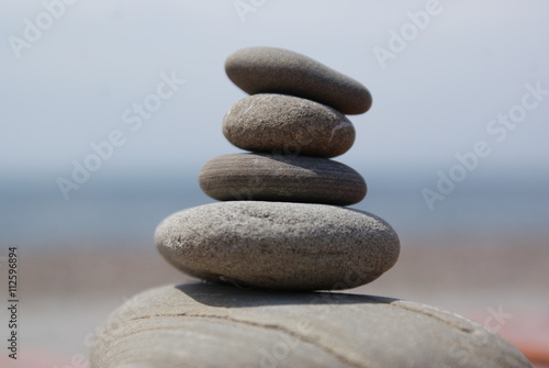 Balanced stones with sea and sky landscape background.