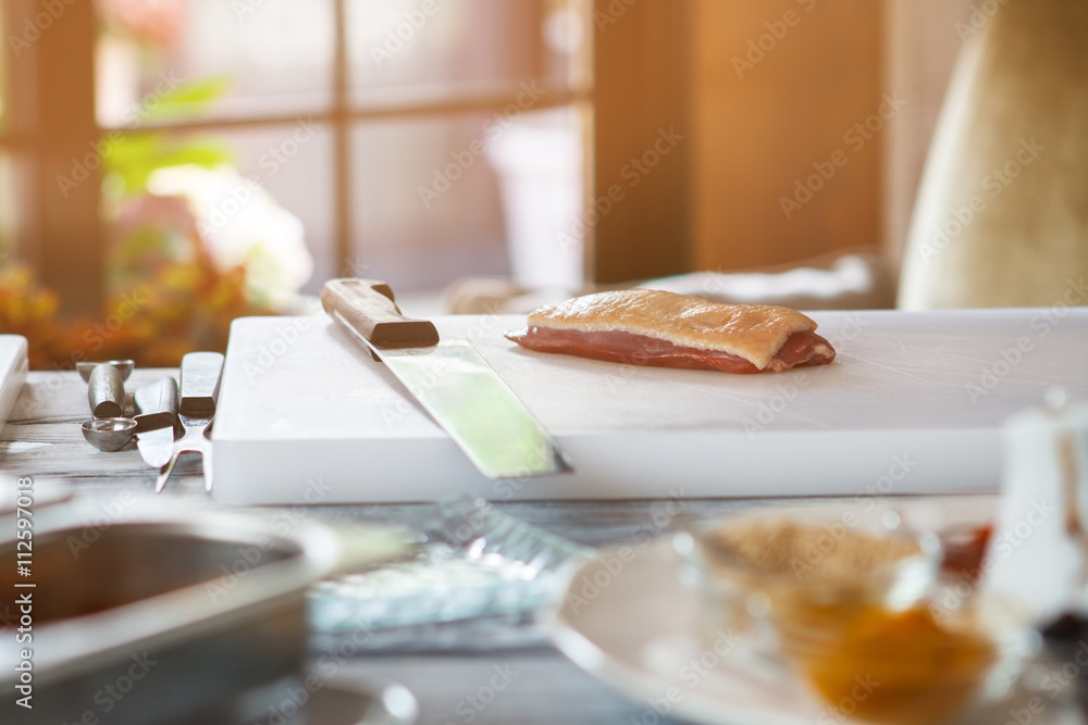Piece of meat and knife. White cooking board with knife. Duck breast for steak. Main ingredient of special dish. Piece of meat and knife. White cooking board with knife. Duck breast for steak. Main ingredient of special dish.