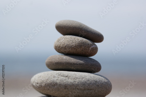 Balanced stones with sea and sky landscape background.