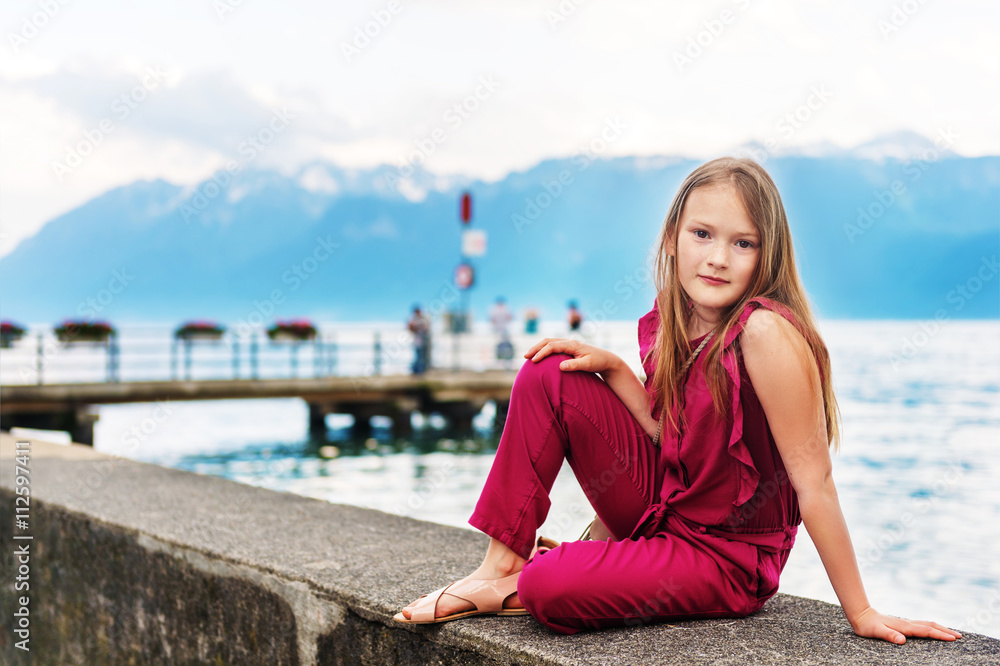 Fashion stylish portrait of pretty preteen girl of 8-9 years old, wearing maroon jumpsuit, posing by the lake Fashion stylish portrait of pretty preteen girl of 8-9 years old, wearing maroon jumpsuit, posing by the lake
