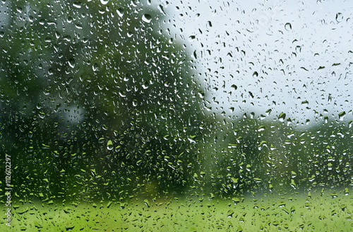 verregnete Landschaft durch ein Fenster mit Regentropfen aufgenommen