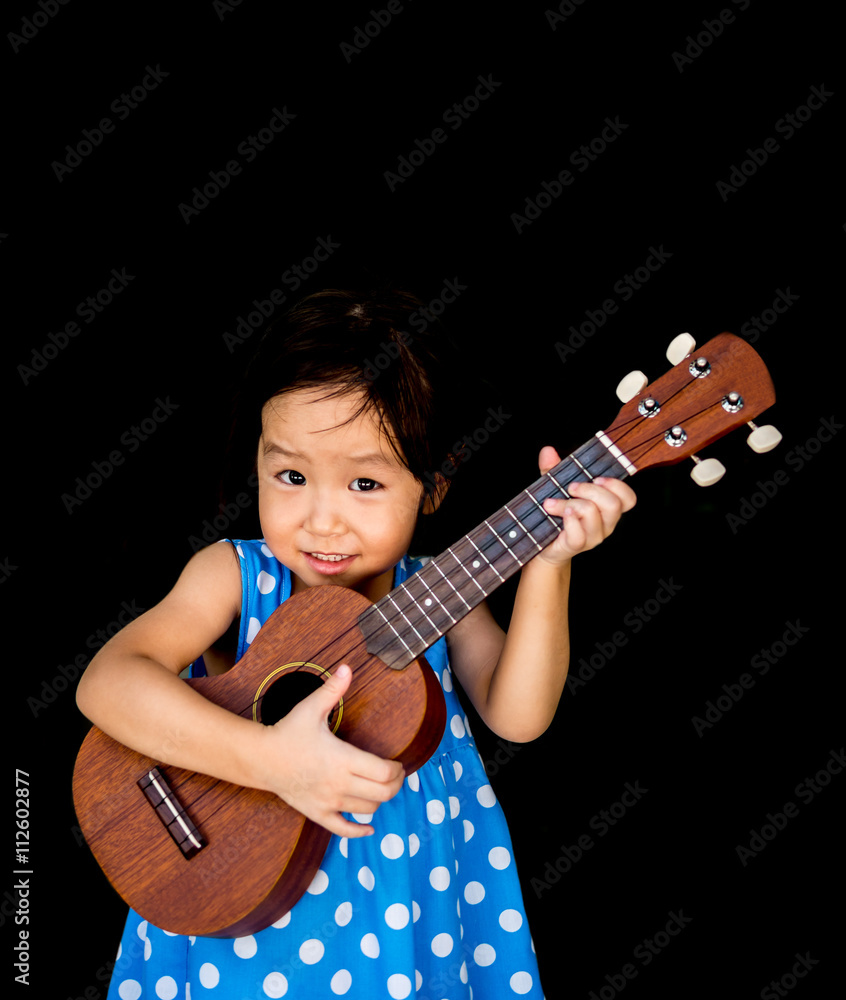 Little asian child play the ukulele Little asian child play the ukulele