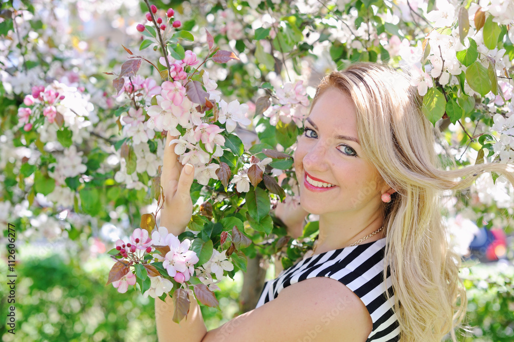 Fototapeta premium young woman in a flowering spring garden