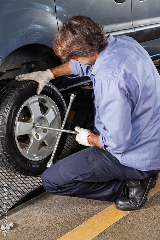 Mechanic Fixing Car Tire With Rim Wrench At Garage