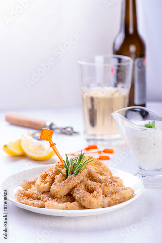 Fried squid rings with lemon, herbs and spices