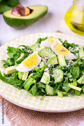 Spinach and avocado salad on white plate