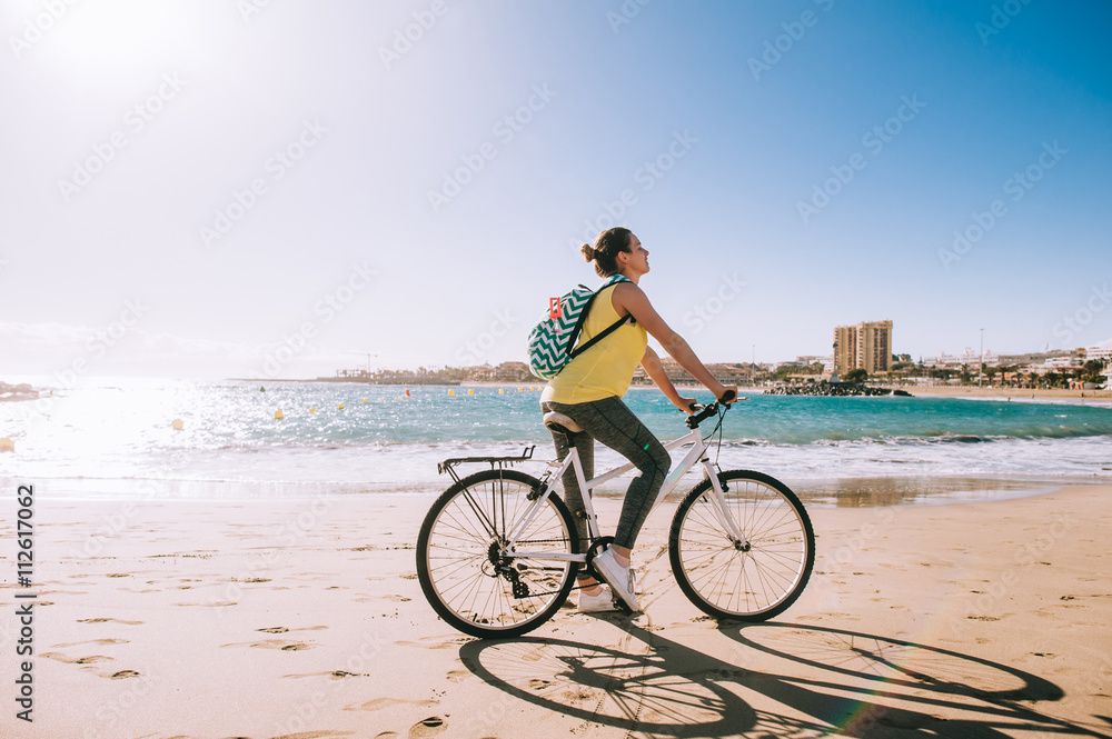 carefree woman with bicycle riding on beach sand having fun and carefree woman with bicycle riding on beach sand having fun and