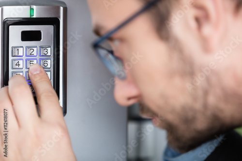 Close up of a man entering security code combination to unlock the door 