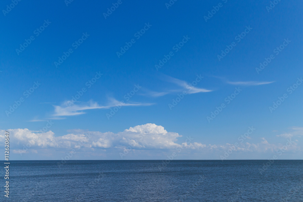 blue sea, blue sky, white cirrus clouds